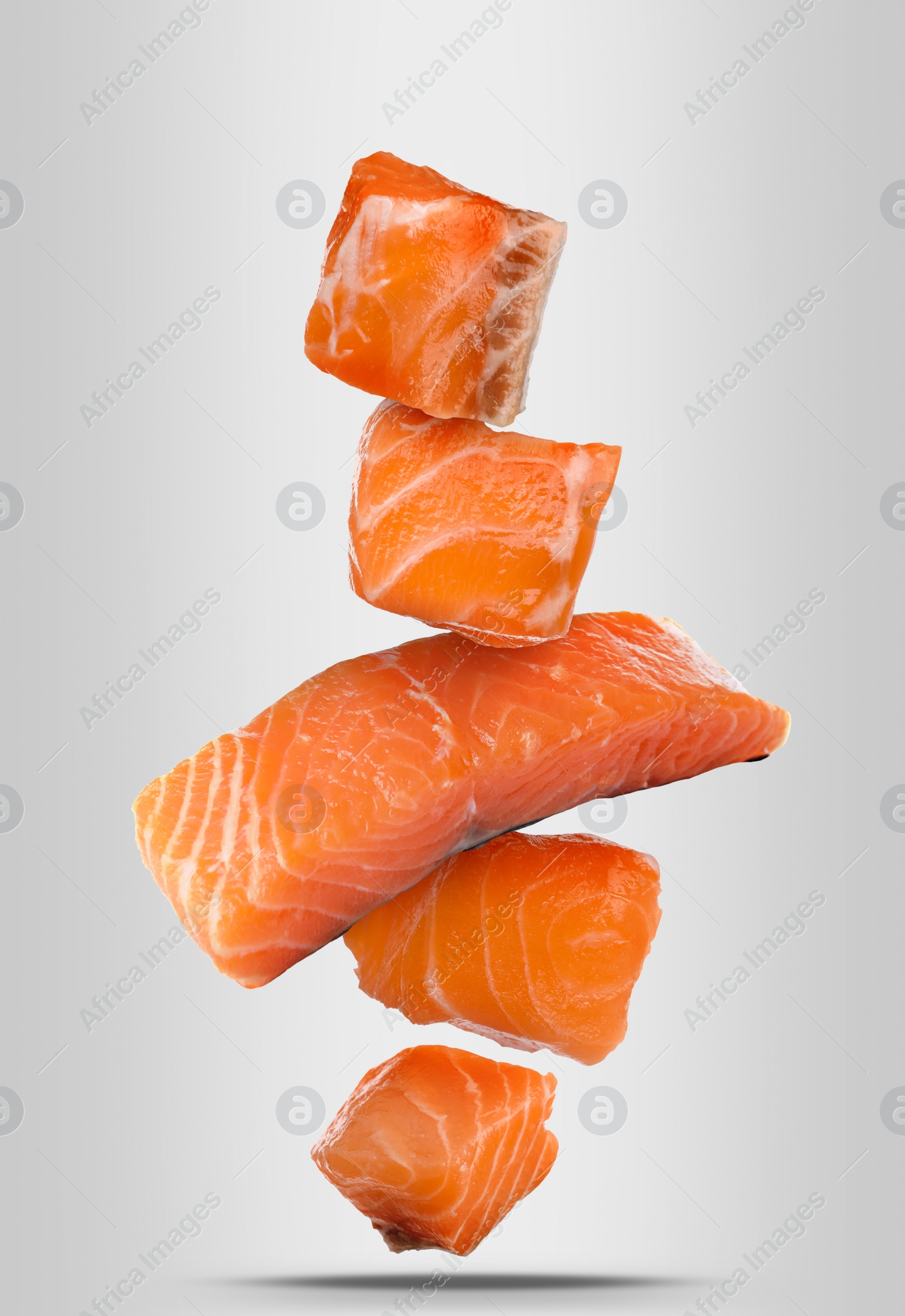 Image of Cut fresh salmon falling on white background