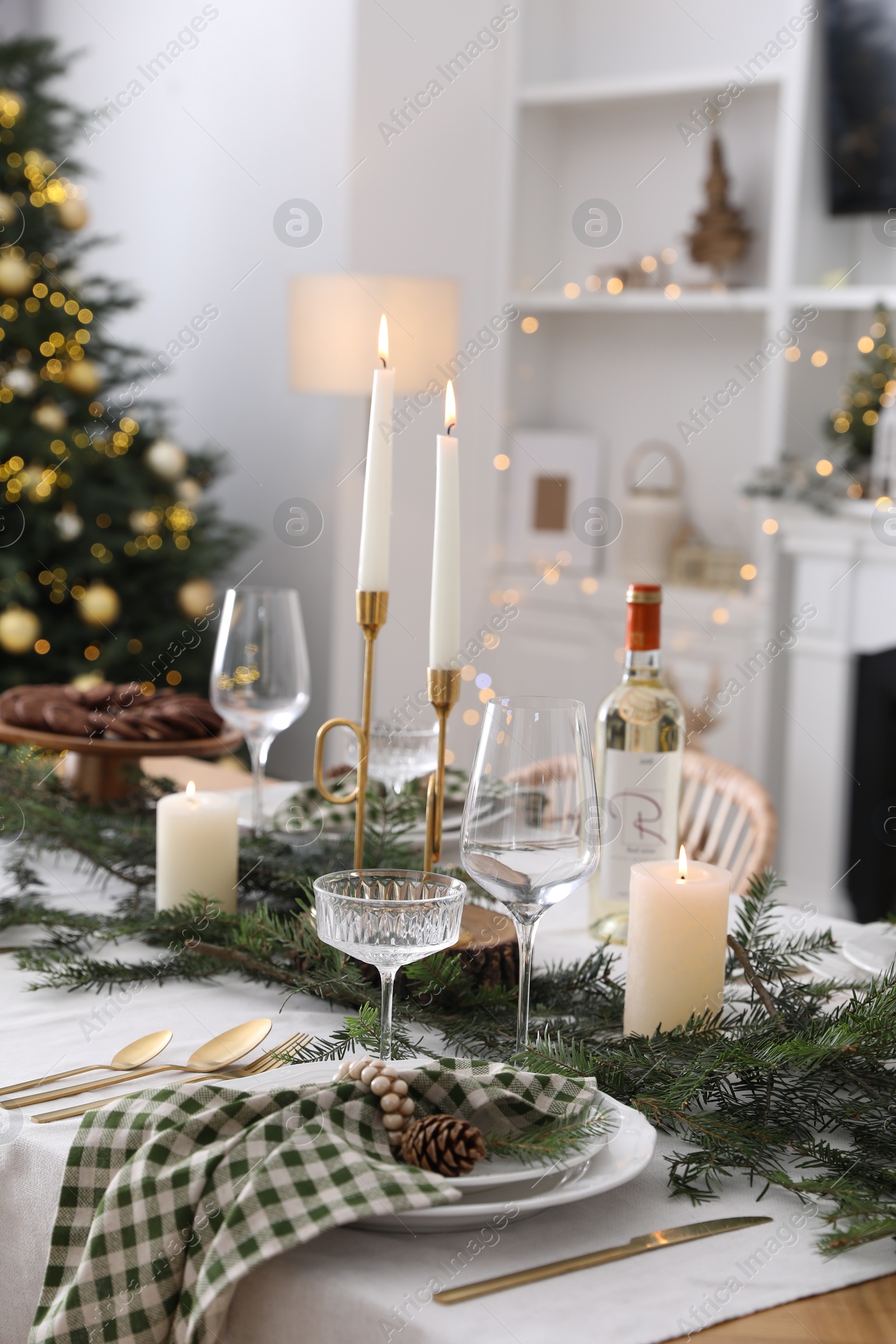 Photo of Christmas table setting with festive decor and dishware in room