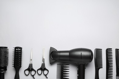 Flat lay composition of professional hairdresser tools on white background, space for text