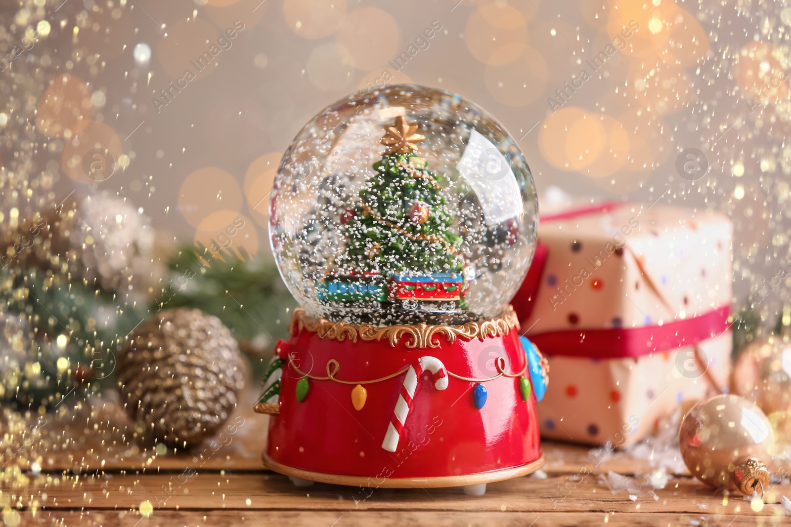 Image of Beautiful snow globe with Christmas tree on wooden table. Bokeh effect