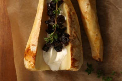 Photo of Tasty baked parsnips with sauce, prunes and thyme on wooden table, flat lay