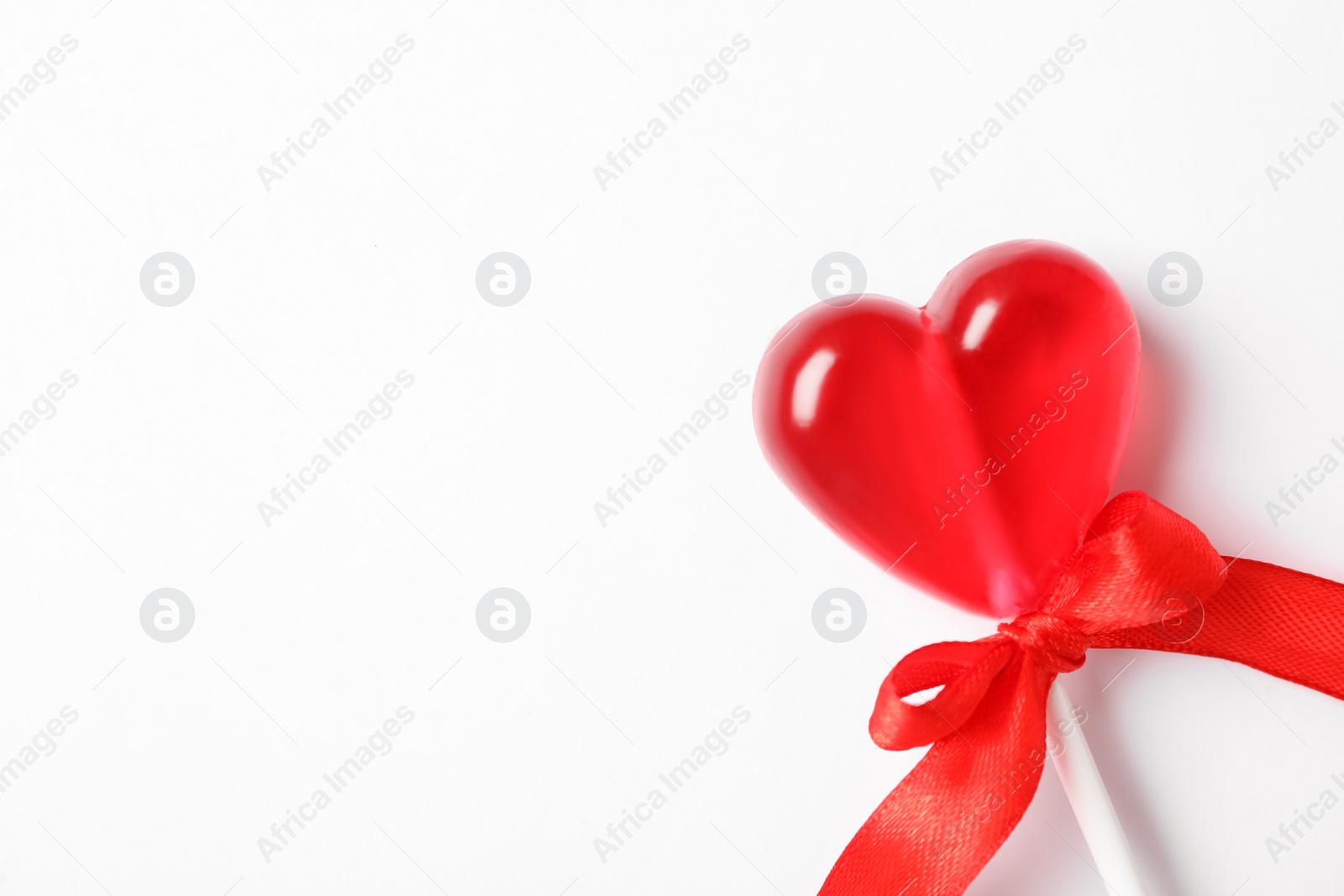 Photo of Sweet heart shaped lollipop on white background, top view with space for text. Valentine's day celebration