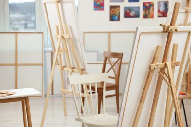Stylish artist's studio interior with chairs in front of easels with canvases. Creative hobby