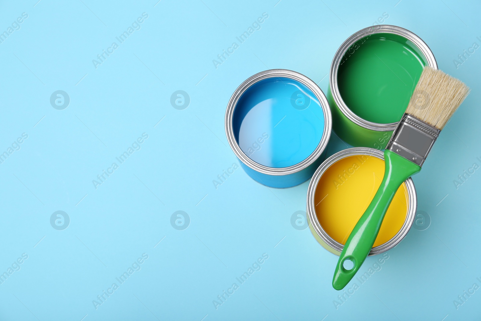 Photo of Flat lay composition with paint cans and brush on color background. Space for text