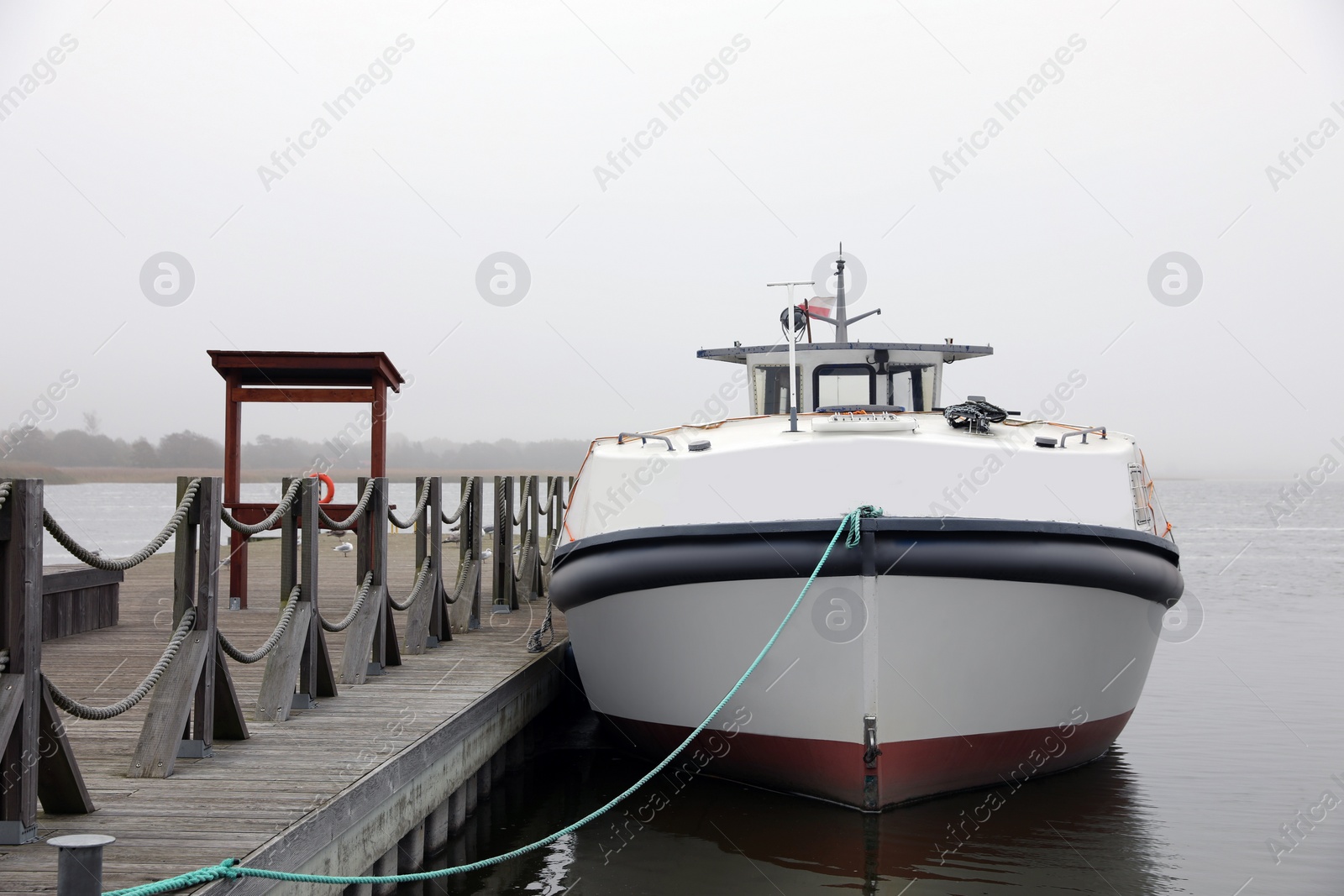 Photo of Picturesque view of wooden pier with moored boat