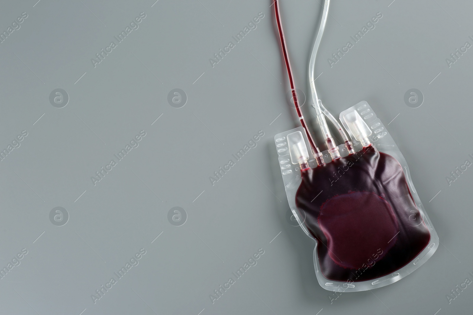 Photo of Blood pack on gray background, top view with space for text. Donation day