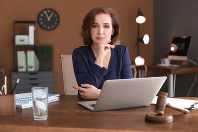 Female lawyer working with laptop at table in office