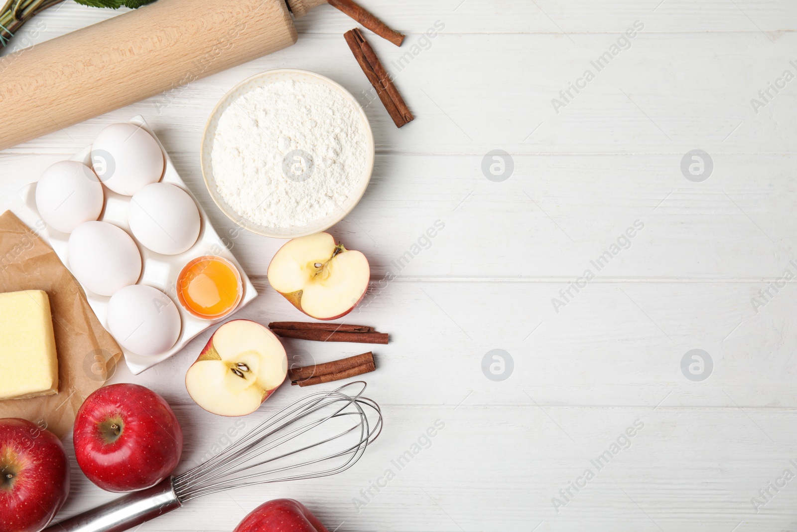 Photo of Traditional English apple pie ingredients on white wooden table, flat lay. Space for text