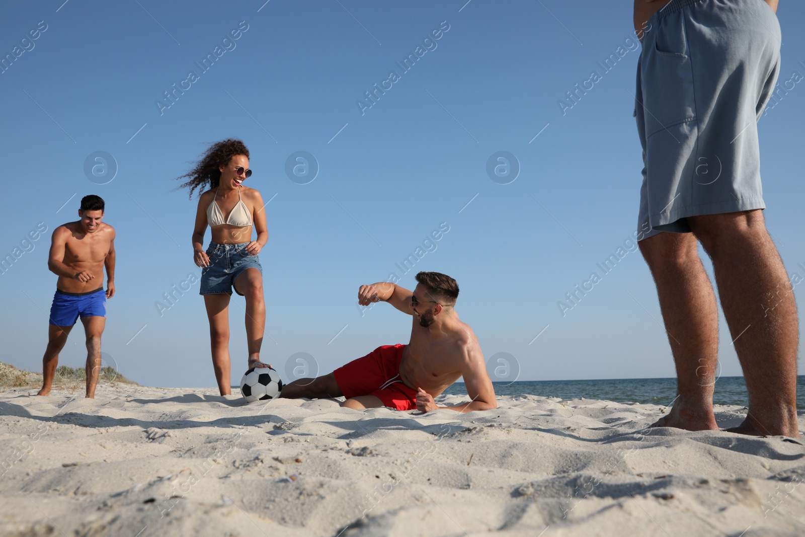 Photo of Group of friends playing football on beach