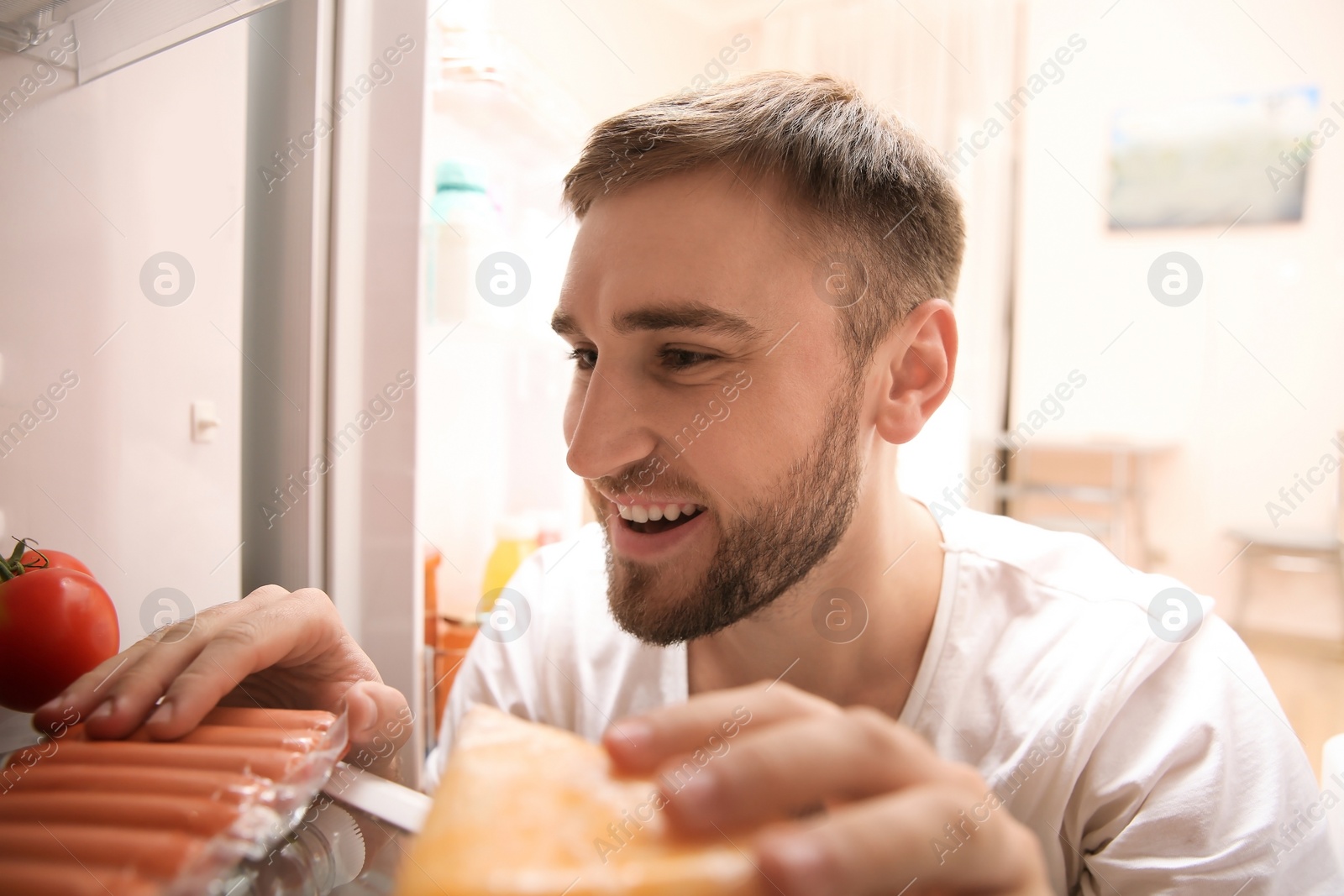 Photo of Young man choosing food in refrigerator, view from inside