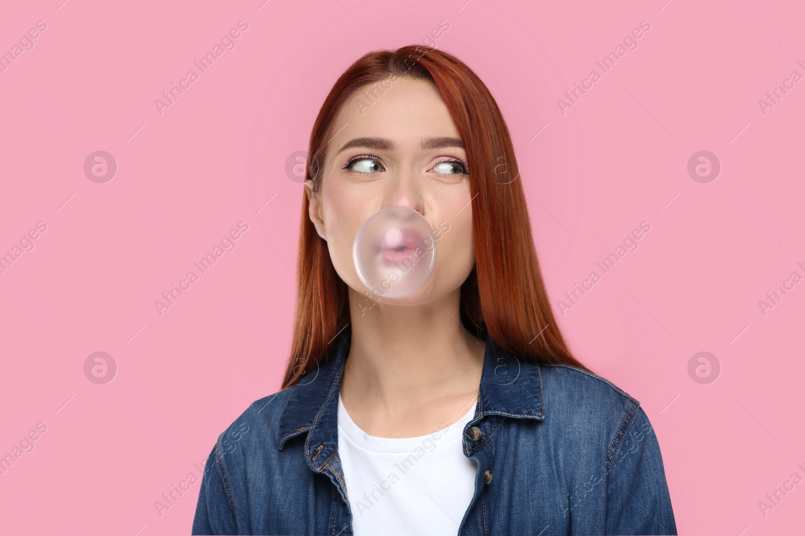 Photo of Portrait of beautiful woman blowing bubble gum on pink background