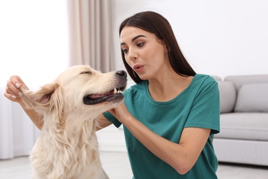 Image of Happy woman with her cute pet dog at home