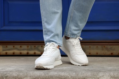 Photo of Man wearing pair of stylish sneakers outdoors, closeup