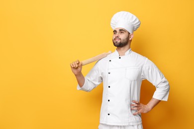 Professional chef with rolling pin on yellow background. Space for text