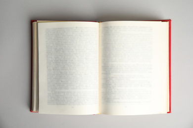 Photo of Open book on light grey background, top view. Space for text