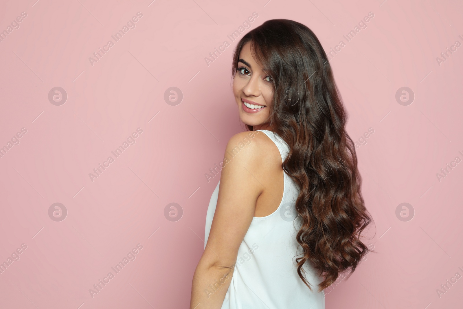 Photo of Beautiful woman with shiny wavy hair on color background