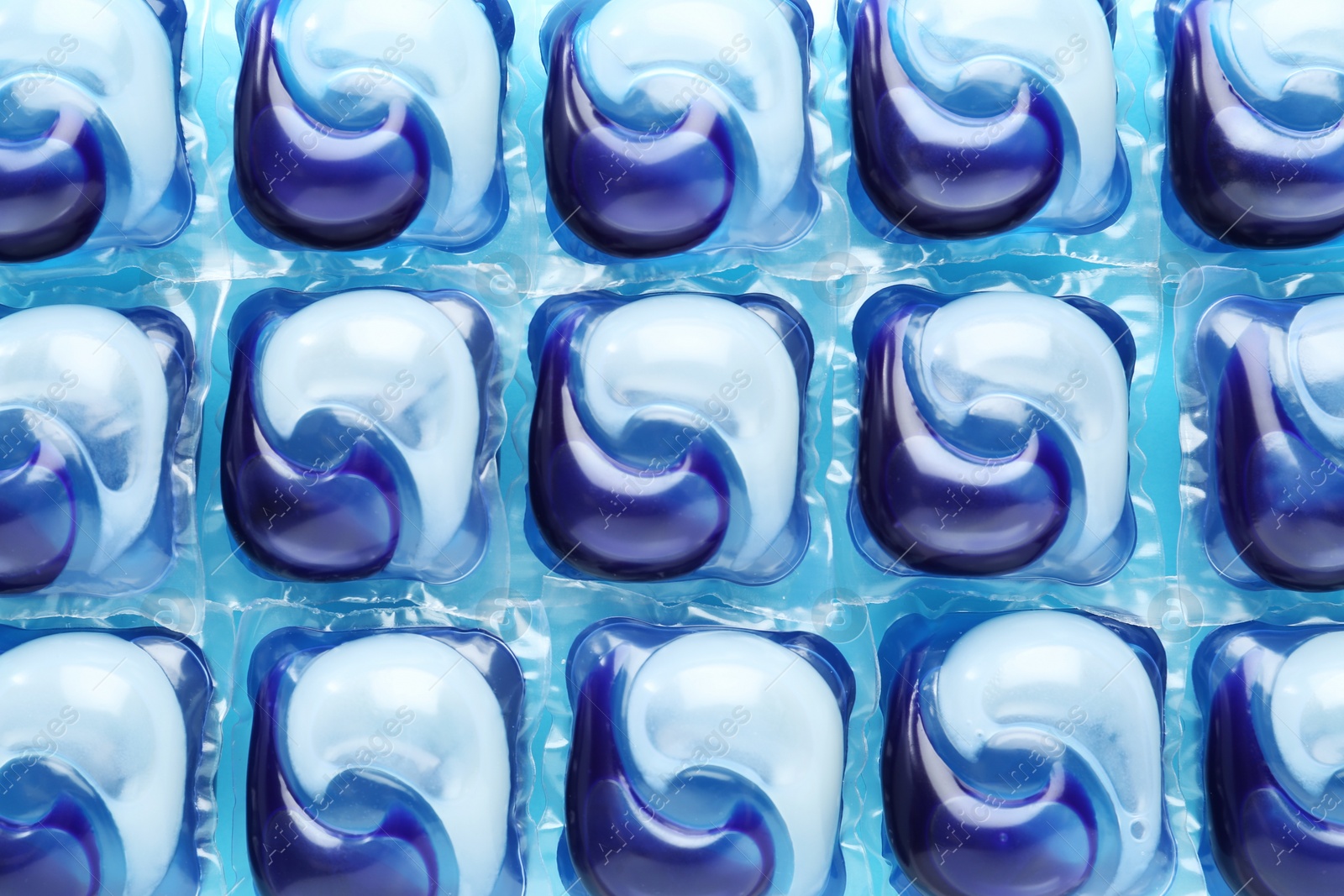 Photo of Laundry capsules on blue background, flat lay