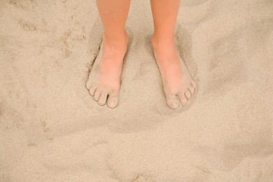 Little girl standing on sandy beach, closeup. Space for text
