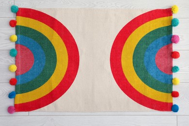Photo of Stylish rug with rainbow on floor, top view