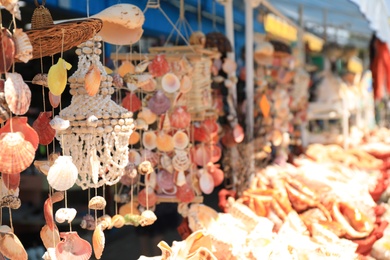 Photo of Wind chimes made of sea shells in outdoor souvenir shop. Space for text