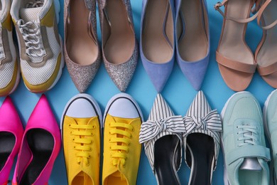 Different shoes on turquoise background, flat lay. Diversity concept