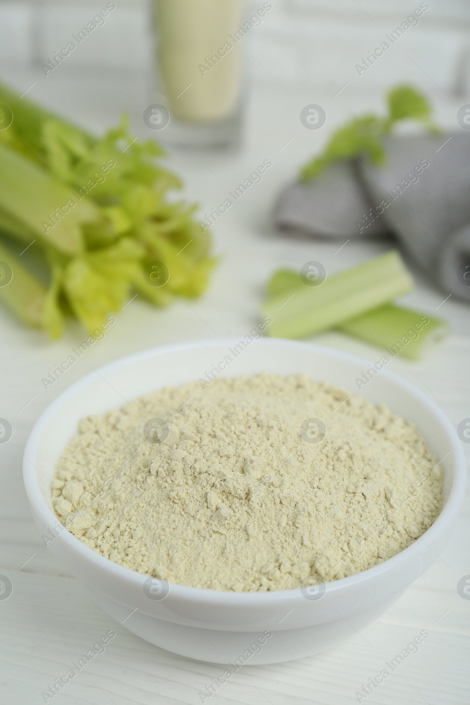 Photo of Natural celery powder in bowl on white table, closeup