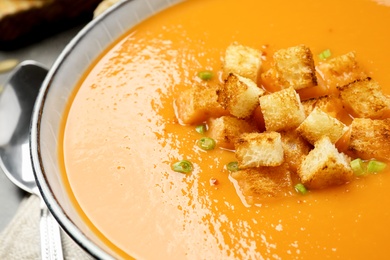 Photo of Tasty creamy pumpkin soup with croutons in bowl on table, closeup
