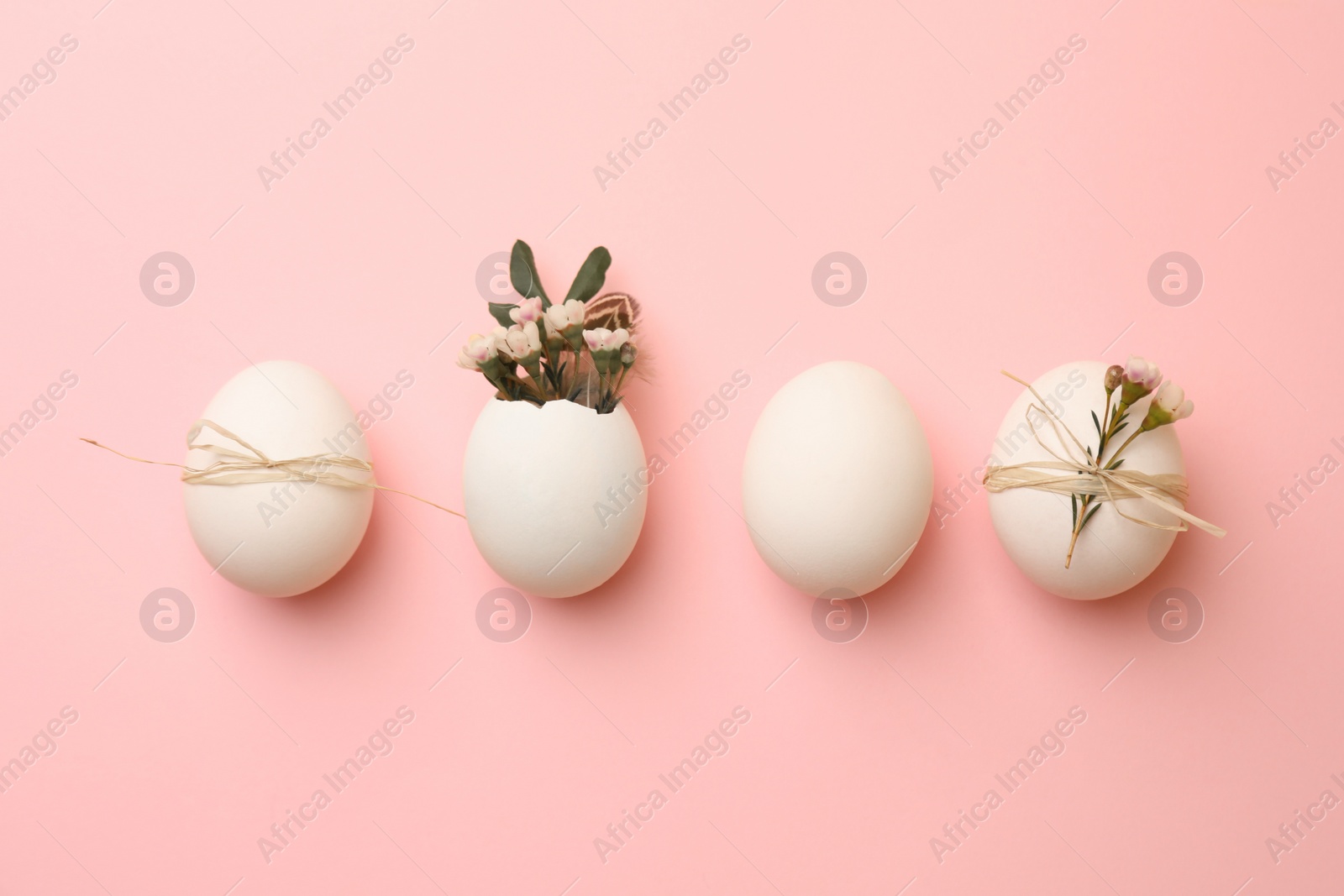 Photo of Chicken eggs and natural decor on pink background, flat lay. Happy Easter