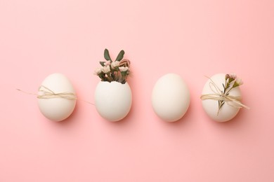 Photo of Chicken eggs and natural decor on pink background, flat lay. Happy Easter