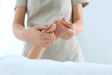 Woman receiving hand massage in wellness center, closeup