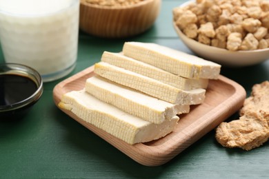 Photo of Different natural soy products on green wooden table, closeup