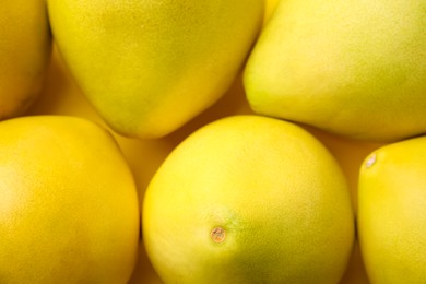 Tasty fresh pomelo fruits on yellow background, top view
