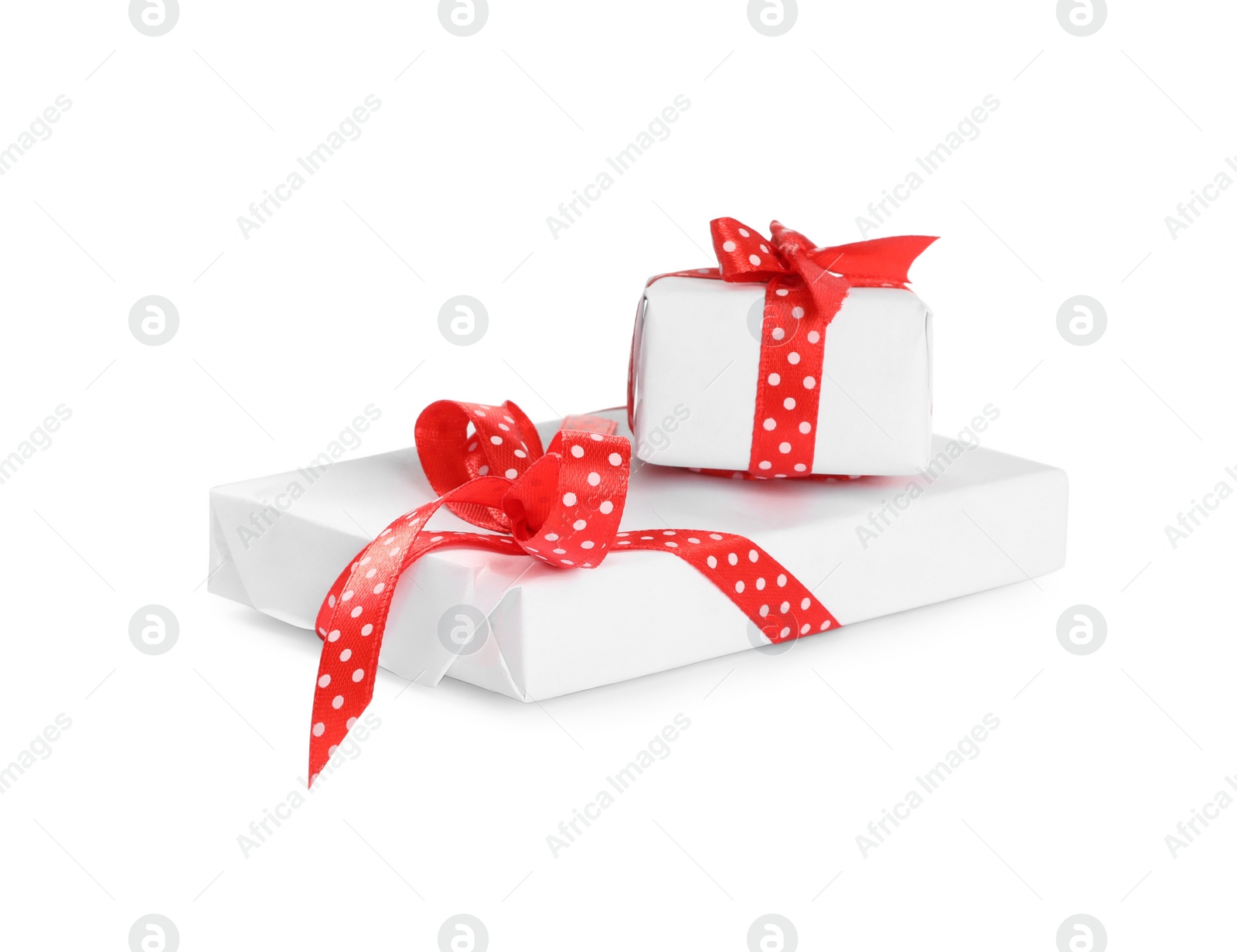 Photo of Christmas gift boxes decorated with red bows on white background