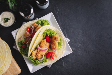 Image of Delicious fish tacos served on dark grey table, flat lay with space for text. Food photography  