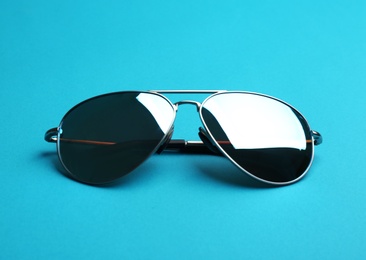 Stylish sunglasses on blue background. Fashionable accessory