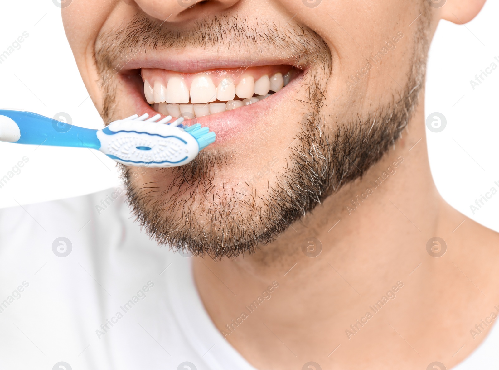 Photo of Young man brushing his teeth on white background