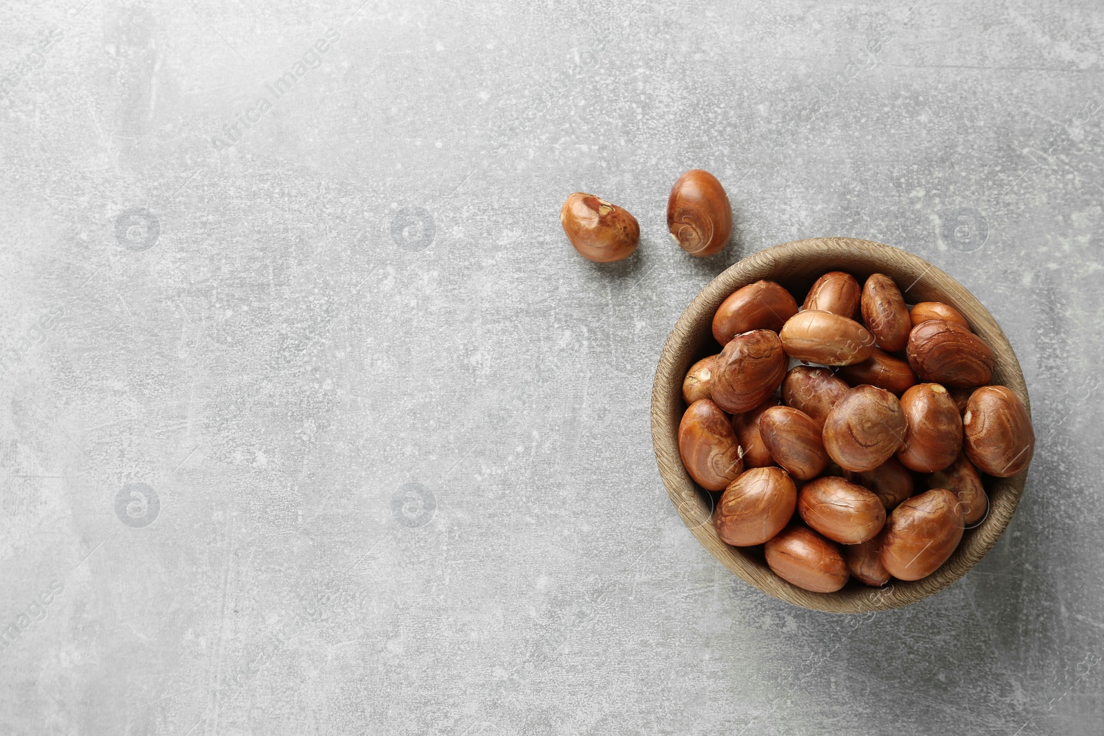 Photo of Bowl with jackfruit seeds on light grey table, flat lay. Space for text