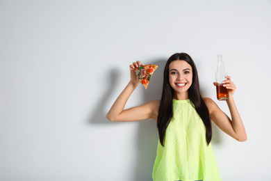Happy woman with pizza and beer on white background, space for text