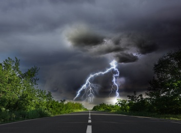 Image of Picturesque view of asphalt road leading to lightning storm