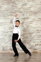 Photo of Beautifully dressed little boy dancing in studio