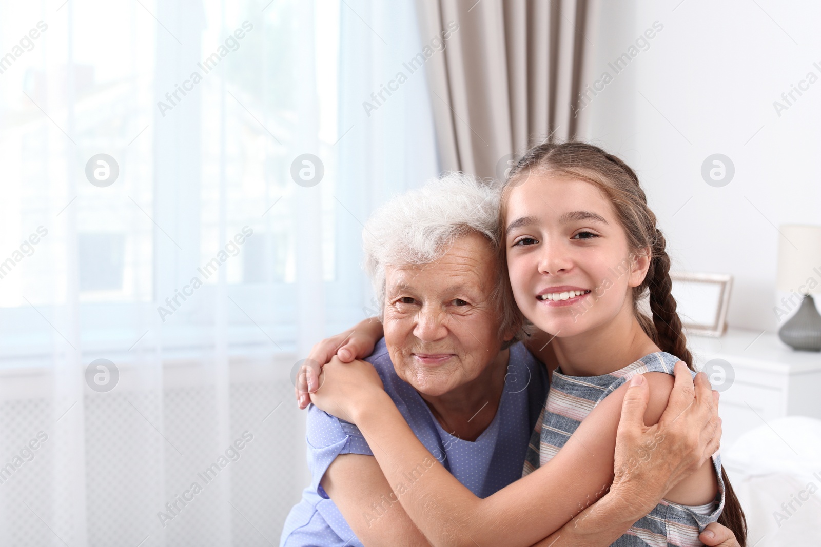 Photo of Happy cute girl with her grandmother at home