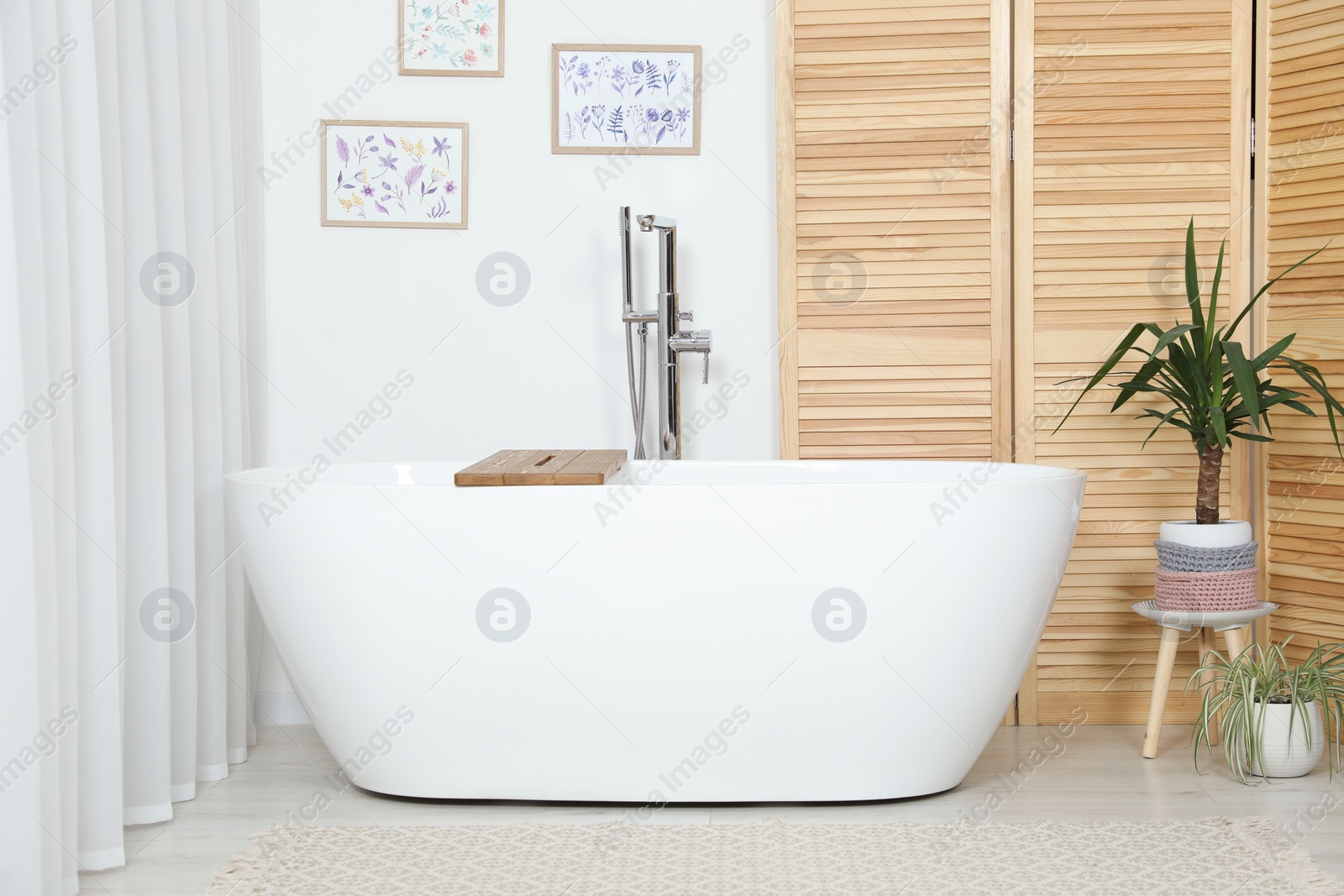 Photo of Stylish white tub in bathroom. Interior design