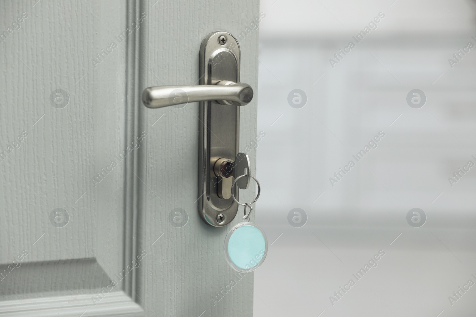 Photo of Key with fob in door lock, closeup. Space for text