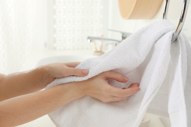 Photo of Woman wiping hands with towel in bathroom, closeup