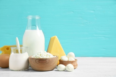 Photo of Different dairy products on white table against blue background. Space for text