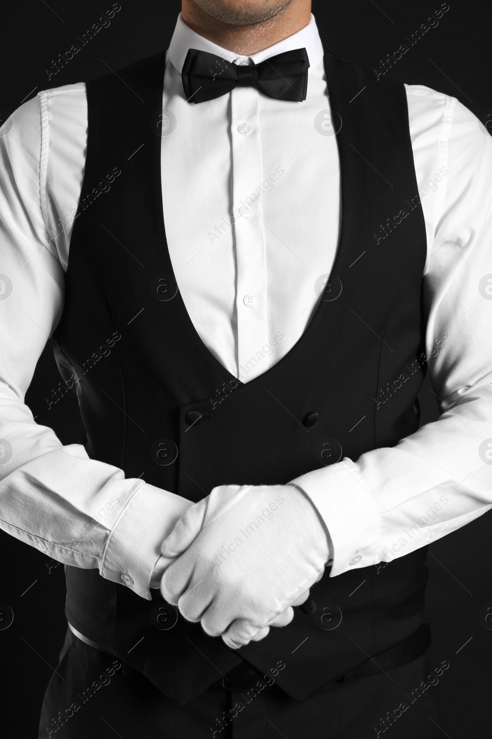 Photo of Butler in elegant uniform on black background, closeup