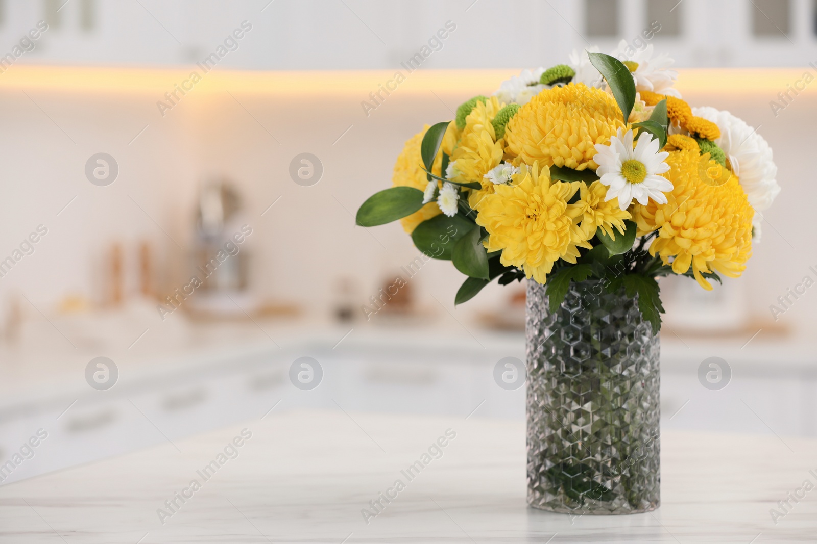 Photo of Bouquet of beautiful chrysanthemum flowers on table in kitchen, space for text