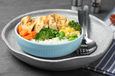 Photo of Plate of boiled rice with vegetables and meat on table