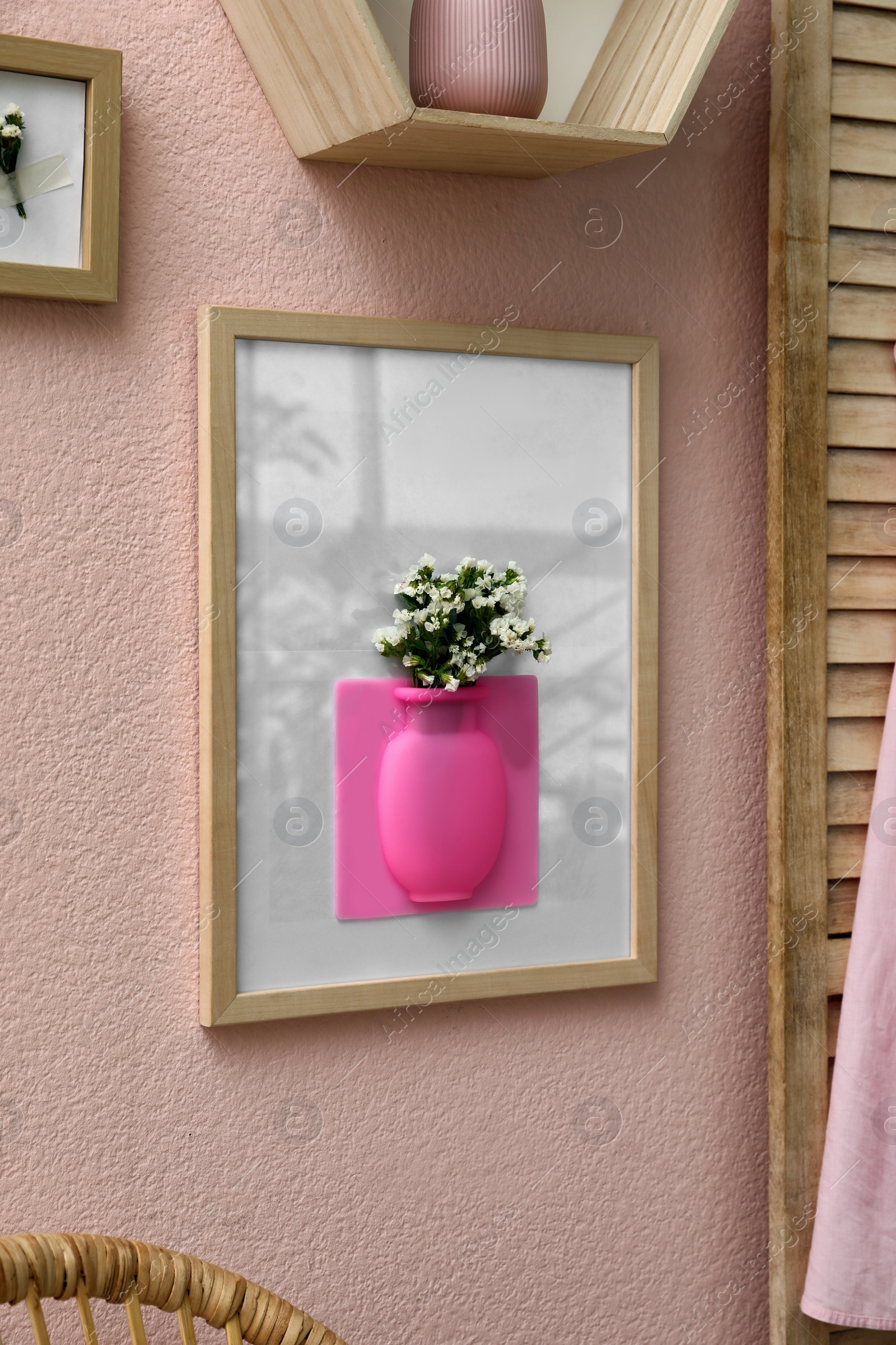 Photo of Silicone vase with beautiful white flowers on pink wall in room