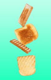 Image of Tasty toasts falling on color background 